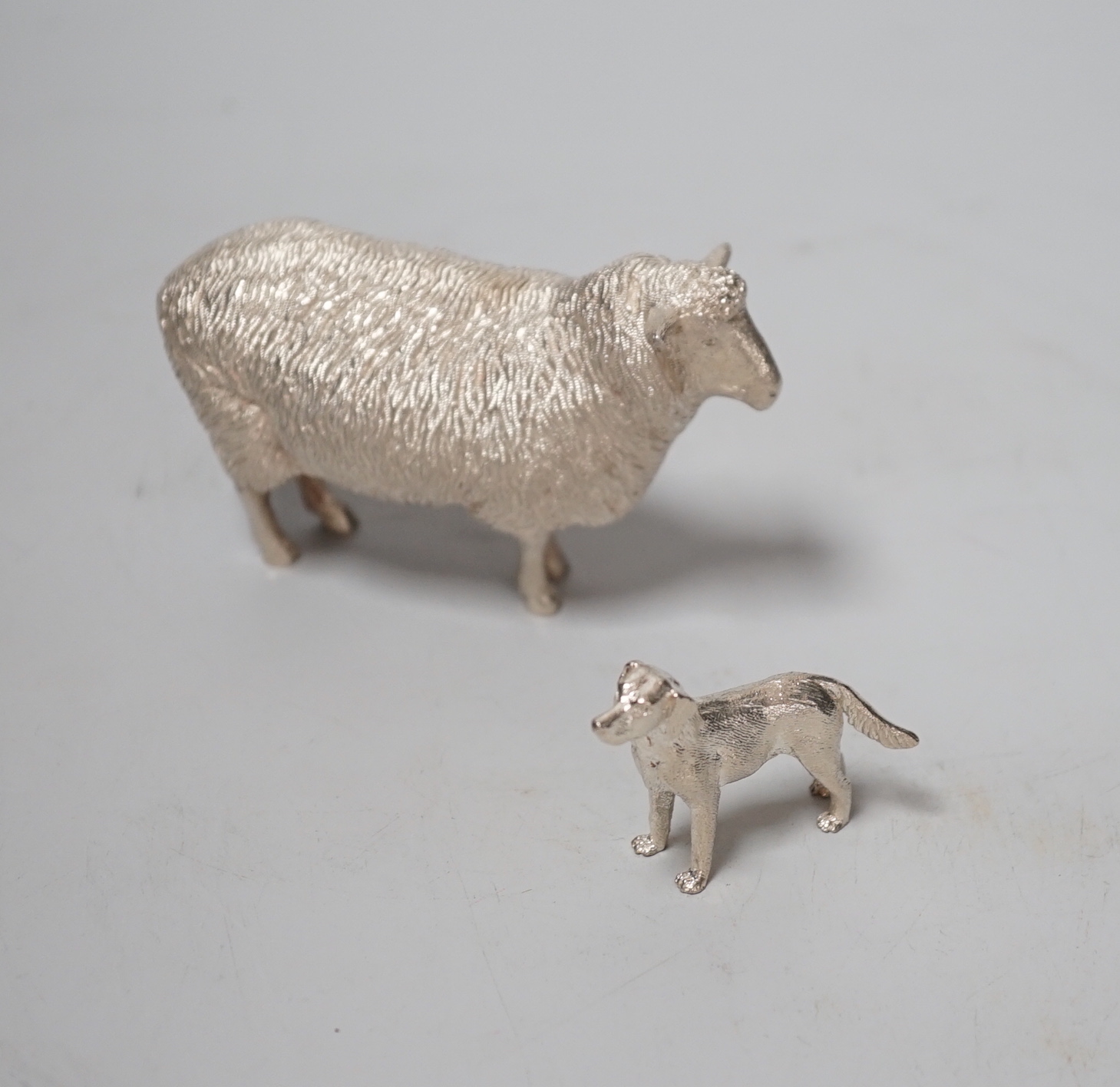 An Elizabeth II silver free-standing model of a sheep, Edward Barnard & Sons Ltd, London, 1993, length 95mm and a smaller silver model free-standing dog, 8.6oz.
